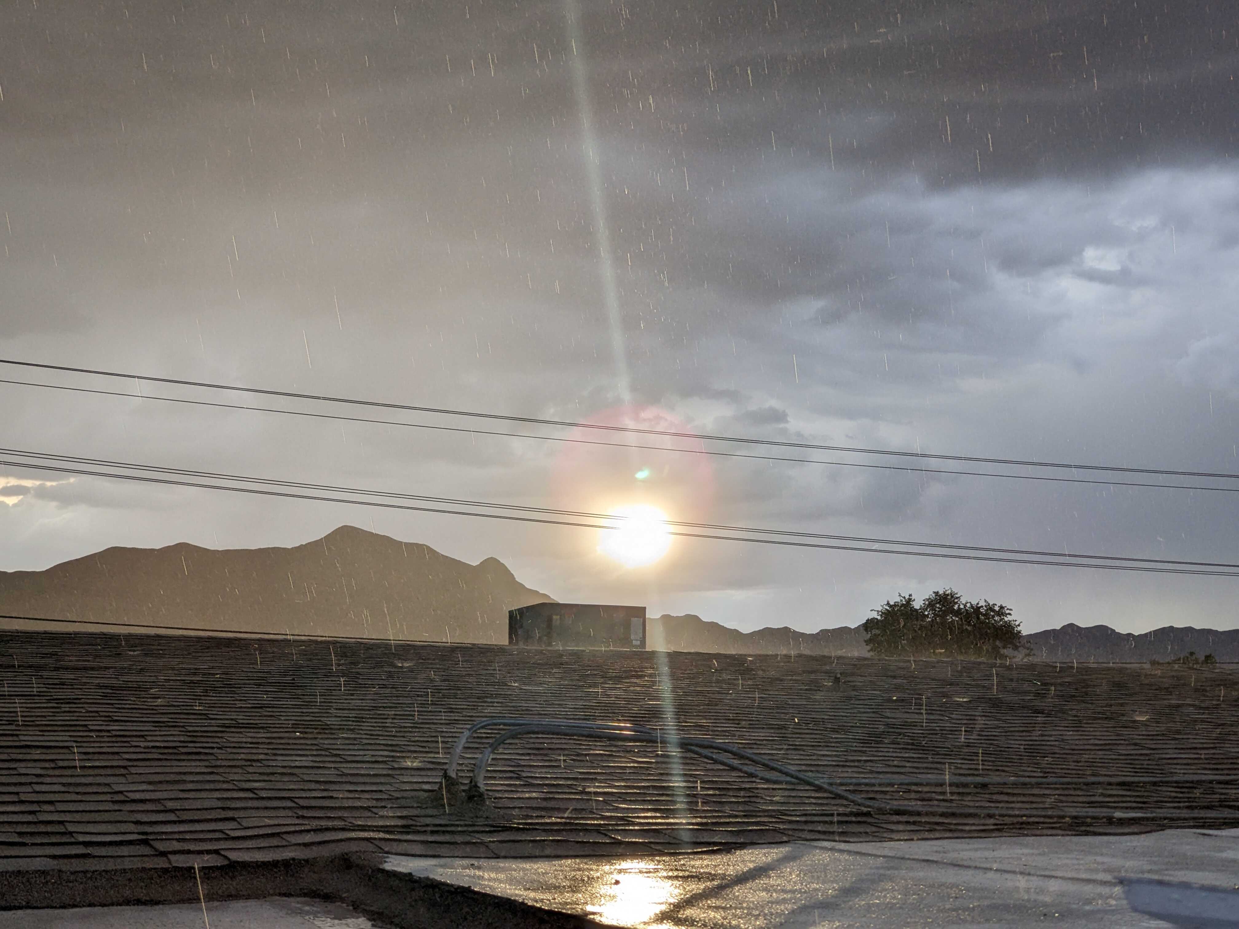 Raindrops falling from sky unto roof.